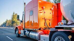 Orange trailer truck defensive driving on Alberta road